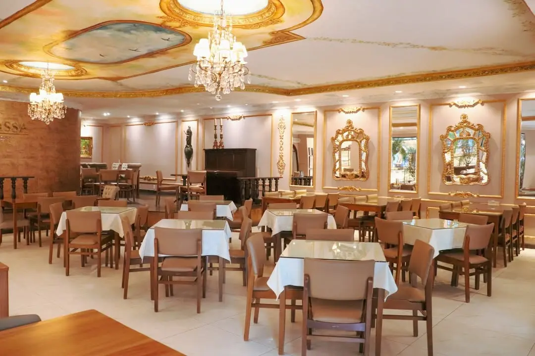 Salão interno do restaurante La Suissa, com mesas e decoração sofisticada